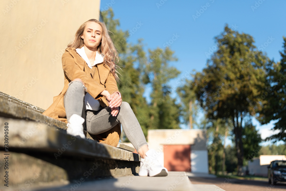 A beautiful young girl walks through the spring city.