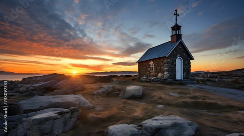 Quaint church perched atop a mountain, bathed in the golden light of a sunset, AI-generated.