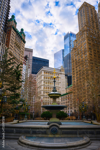 New York City Hall Park, Skyline, Buildings, and Dramatic Cumulus Clouds over the Historical Landmark Jacob Wrey Mould Fountain in the Greenspace near government buildings in Manhattan photo