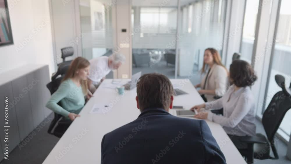 Executive manager starting meeting with business team in boardroom, back view. Company team lead and office employees group taking seats in conference room Executive manager starting meeting with business team in boardroom, back view. Company team lead and office employees group taking seats in conference room