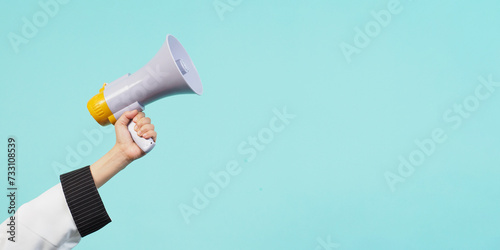 Hand hold megaphone and wear chef uniform on green mint or Tiffany Blue background.