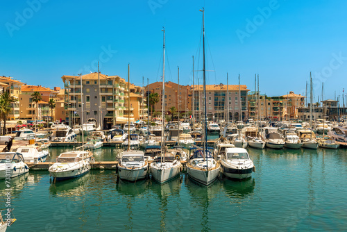 Yachts and boats and residential buildings on background in Frejus, France.
