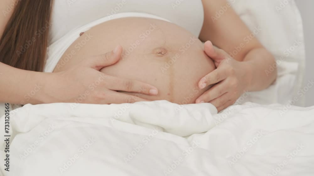 beautiful pregnant woman, sitting on bed in bedroom, preparing to give a birth beautiful pregnant woman, sitting on bed in bedroom, preparing to give a birth
