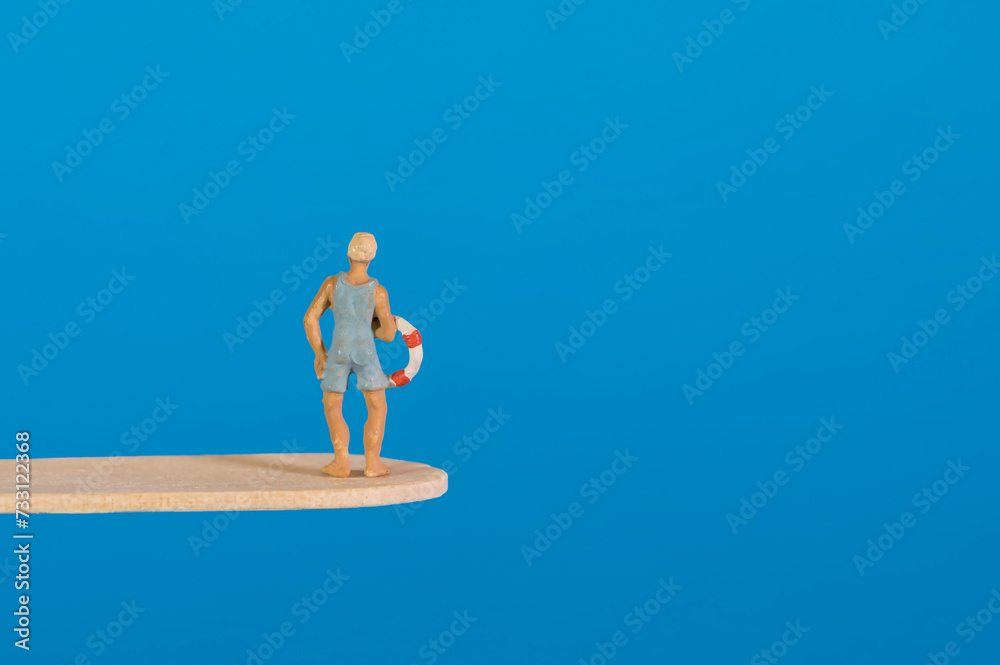Swimmer with lifebuoy on a diving board, blue background