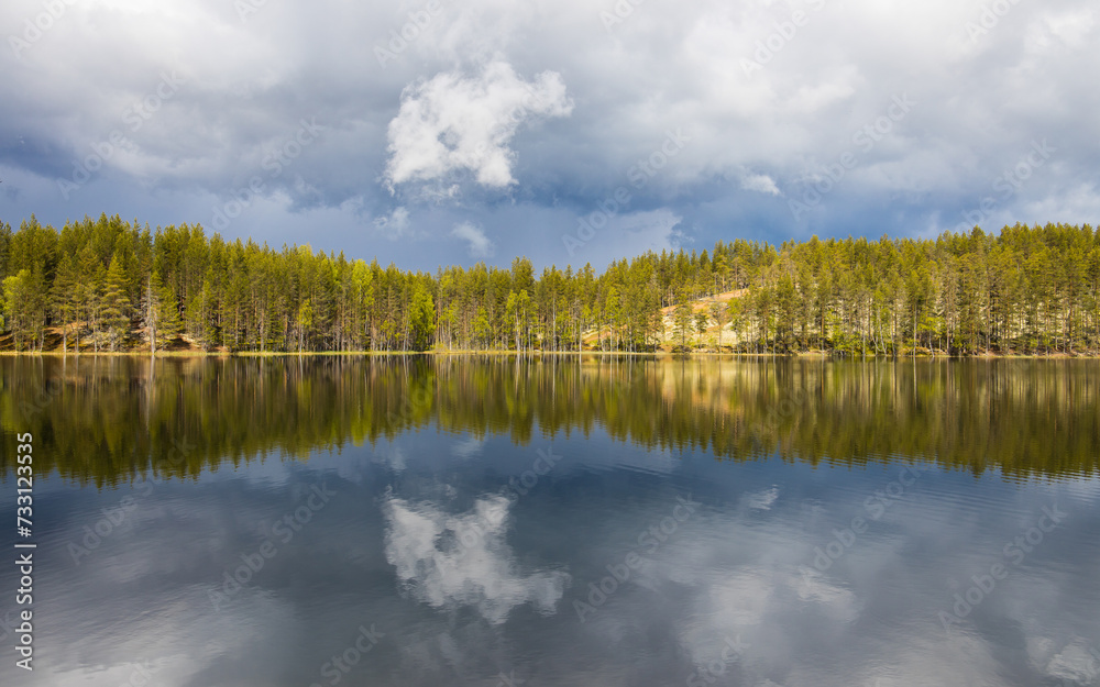Dramatic cloudscape with a raising storm on a finnish lake surrounded by forest. Deep nature in Lapland, Finland. Dramatic cloudscape with a raising storm on a finnish lake surrounded by forest. Deep nature in Lapland, Finland.
