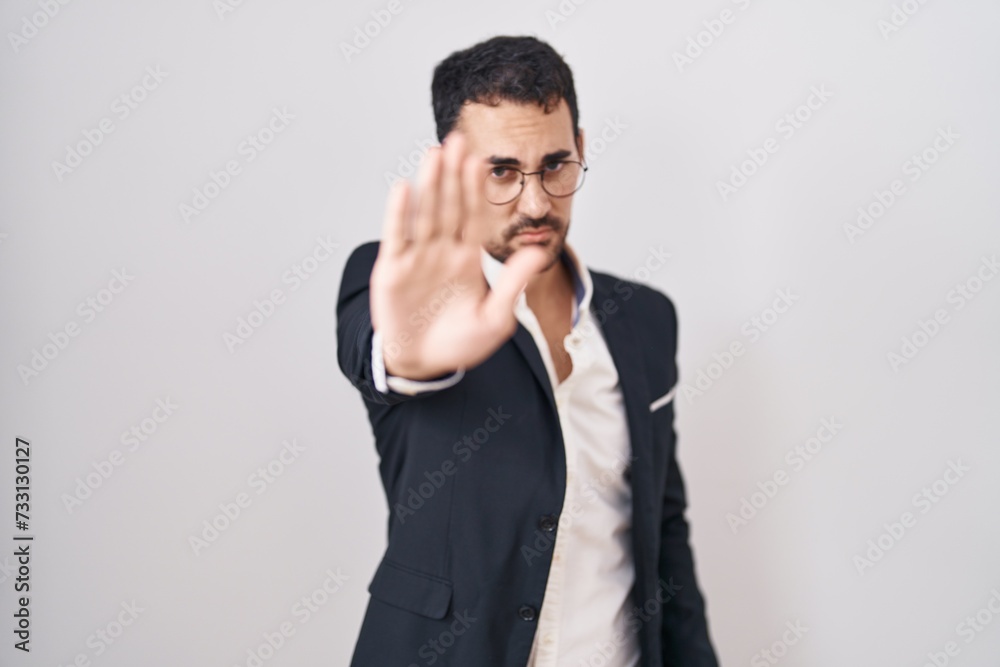 Handsome business hispanic man standing over white background doing stop sing with palm of the hand. warning expression with negative and serious gesture on the face. Handsome business hispanic man standing over white background doing stop sing with palm of the hand. warning expression with negative and serious gesture on the face.