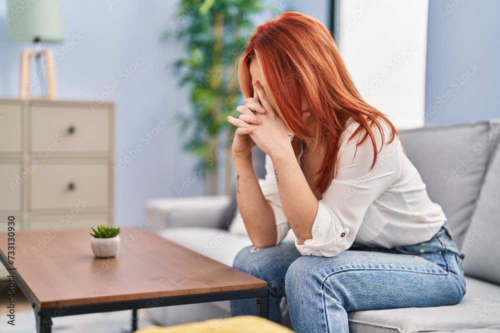 Young caucasian woman stressed sitting on sofa at home Young caucasian woman stressed sitting on sofa at home