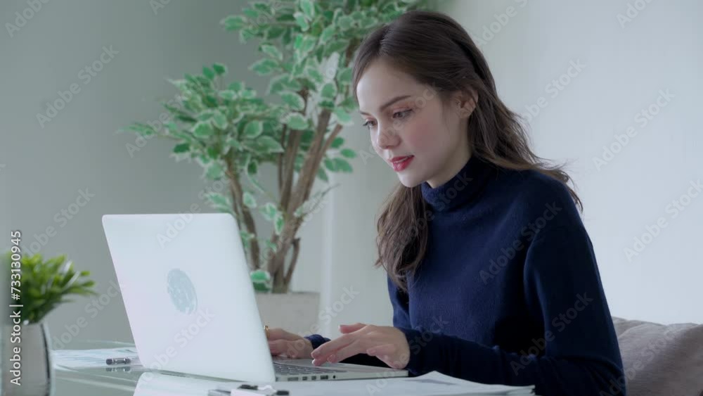 Asian woman in casual clothes uses computer at working space Asian woman in casual clothes uses computer at working space