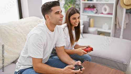 A man and woman play video games together in a cozy living room, exemplifying leisure time and couple bonding at home.