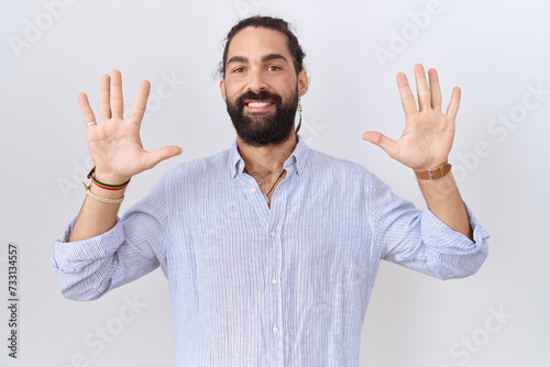 Hispanic man with beard wearing casual shirt showing and pointing up with fingers number ten while smiling confident and happy.