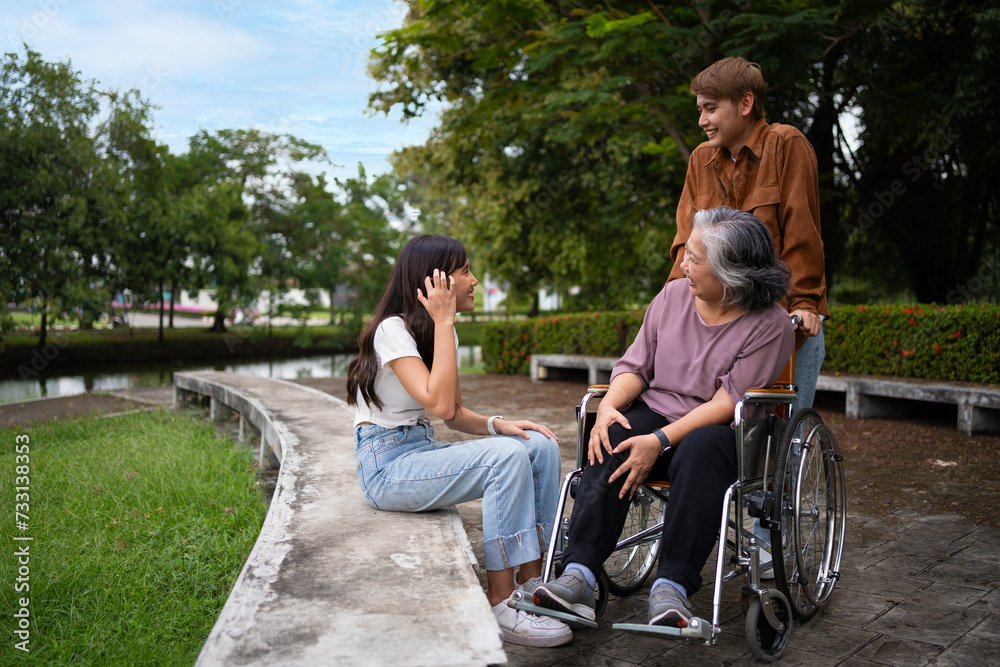 Asian careful caregiver or nurse taking care of the patient in a wheelchair. Concept of a happy retirement with care from a caregiver and Savings and senior health insurance, a Happy Family Asian careful caregiver or nurse taking care of the patient in a wheelchair. Concept of a happy retirement with care from a caregiver and Savings and senior health insurance, a Happy Family