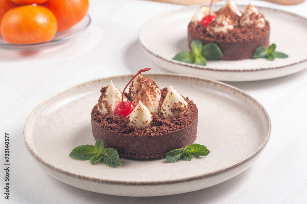 Delicious chocolate tart garnish with cherry and mint. Classic dessert. Delicious chocolate tart garnish with cherry and mint. Classic dessert.