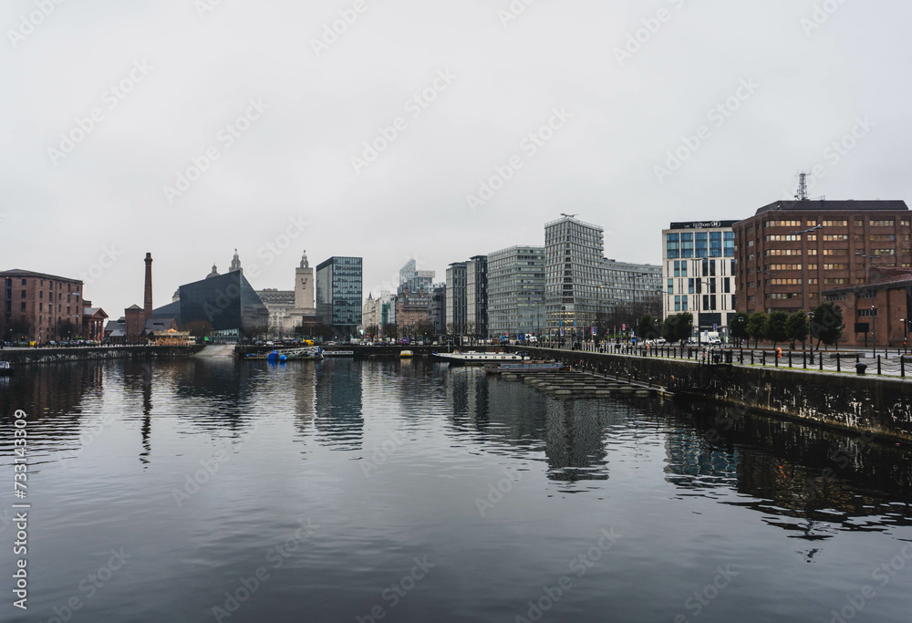 city skyline of liverpool alber docks on rainy day with modern contrast and old important buildings 