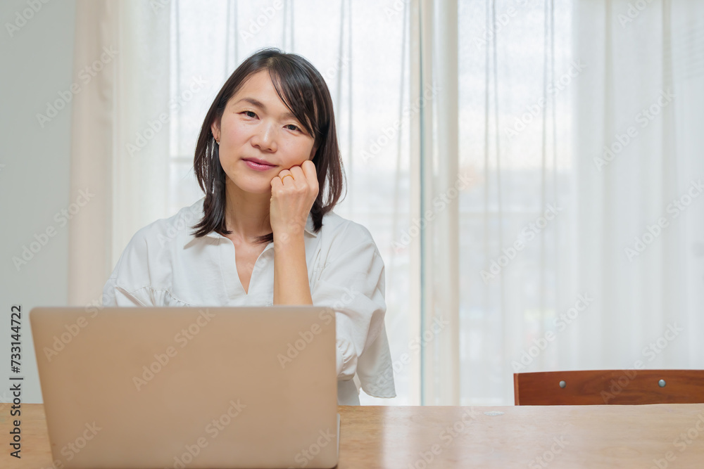 パソコンを使いこちらを見つめる女性