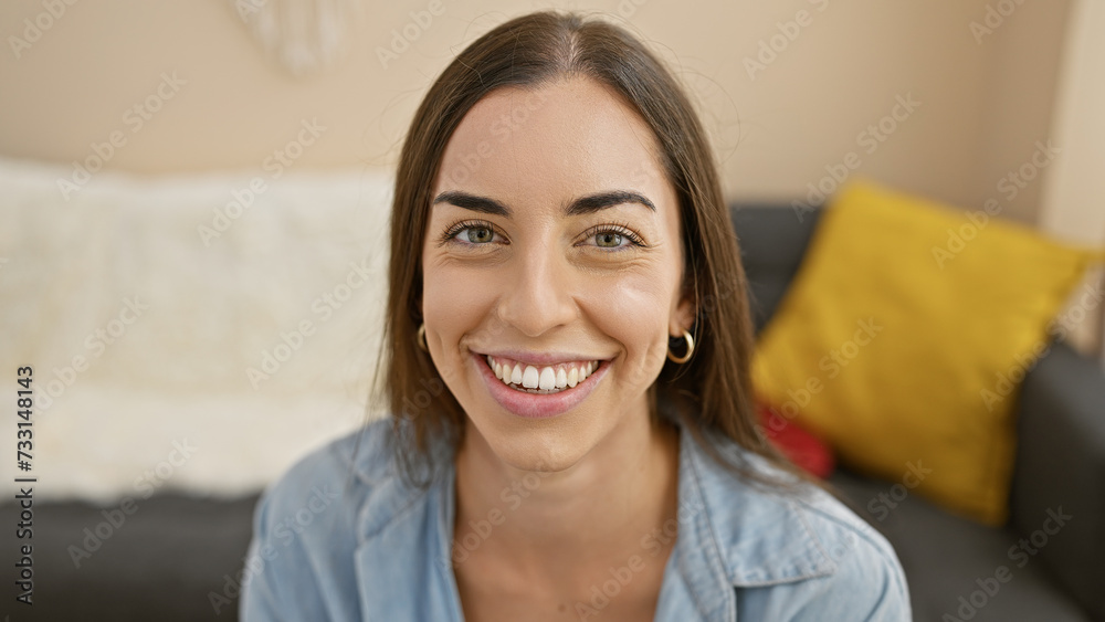 A joyful moment capturing a young, beautiful hispanic woman, radiating confidence, smiling while she enjoys a rest on the cozy sofa in her comfortable home. A joyful moment capturing a young, beautiful hispanic woman, radiating confidence, smiling while she enjoys a rest on the cozy sofa in her comfortable home.