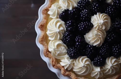 Close-up of blackberry pie with whipped cream swirls