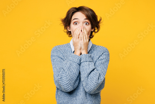 Young shocked surprised excited fun woman she wears grey knitted sweater shirt casual clothes look camera cover mouth with hands isolated on plain yellow background studio portrait. Lifestyle concept. photo