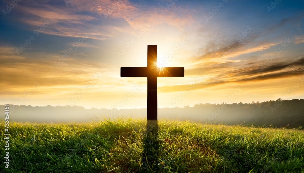 silhouette christian cross on grass in sunrise background
