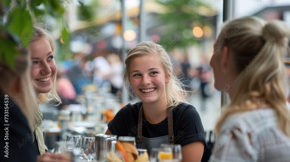 Portrait of smiling young woman in restaurant and smiling waitress.