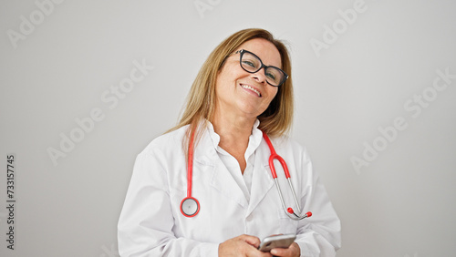 Middle age hispanic woman doctor smiling using smartphone over isolated white background