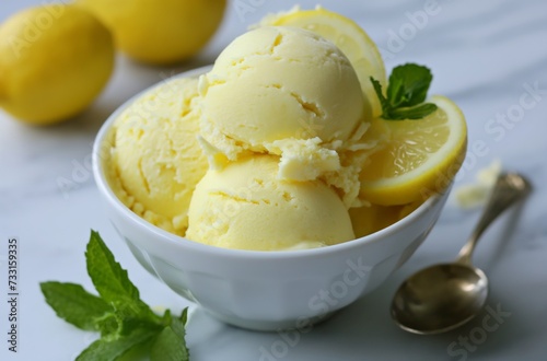 Bowl of lemon-flavored ice cream with lemon slices and mint leaves, silver spoon on the side