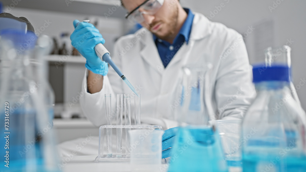 Young hispanic man scientist pouring liquid on test tube at laboratory Young hispanic man scientist pouring liquid on test tube at laboratory