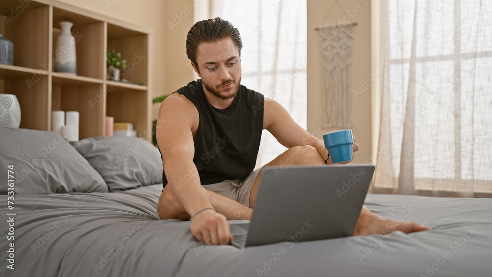 Young hispanic man using laptop drinking coffee at bedroom Young hispanic man using laptop drinking coffee at bedroom