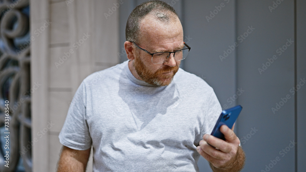 Caucasian man using smartphone with serious expression at street Caucasian man using smartphone with serious expression at street