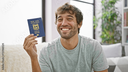 Tableau sur toile Confident, bearded young man joyfully flashing his israeli passport, casually si