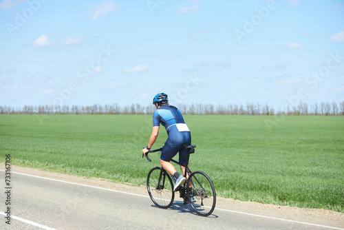 An athlete in cycling or triathlon competitions. A man in a bicycle uniform and helmet. Check-in on the highway