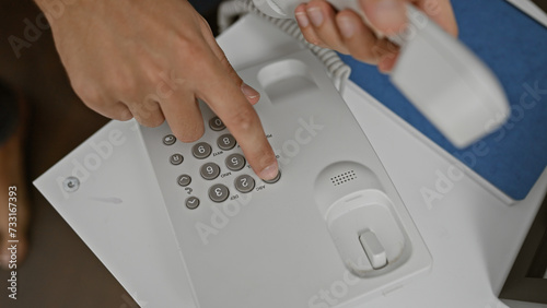 Close-up of a person's hand dialing on a landline phone, suggesting communication, technology, or customer service.