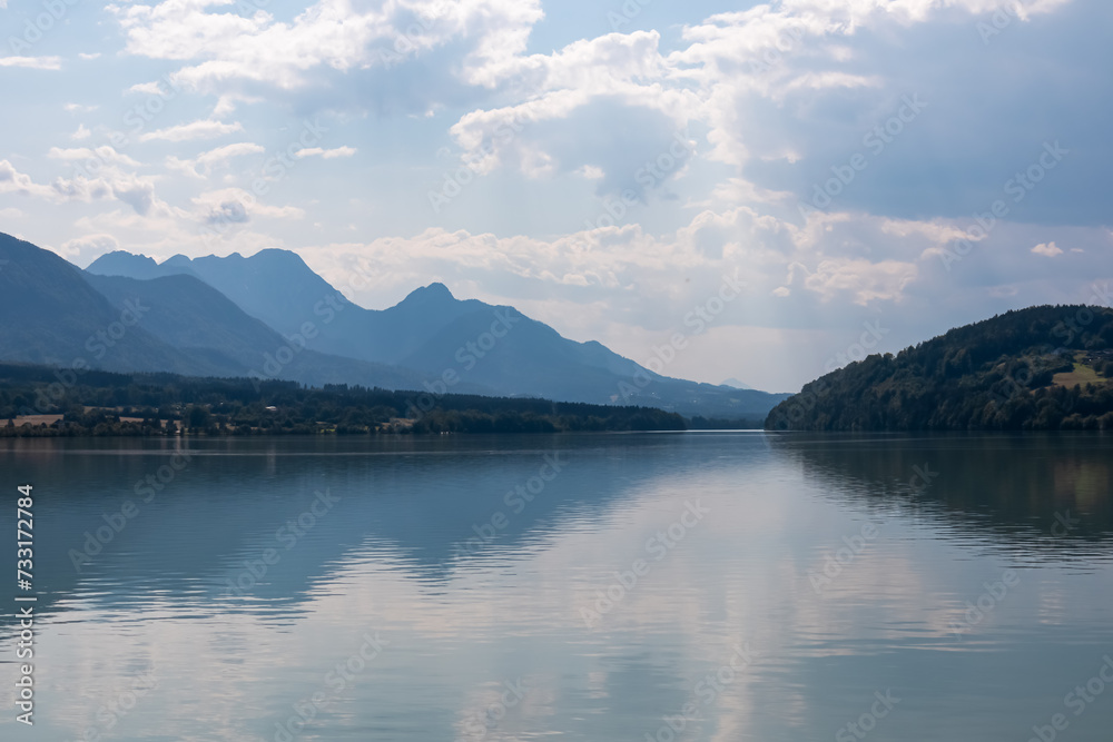 Idyllic river Drava with with scenic view of untamed mountain peaks of Karawanks, Feistritz im Rosental, Carinthia, Austria. Looking at majestic Mittagskogel summit in summer. Hiking in Austrian Alps
