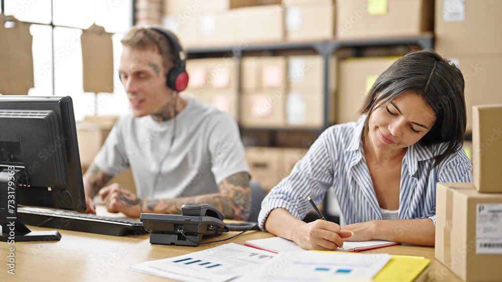 Fototapeta premium Two ecommerce business workers working together at office