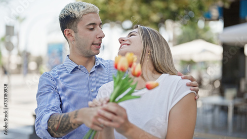 Beautiful couple surprise with bouquet of flowers at street