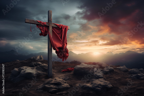 A christian cross with a red cloth, on top of the mountain against sunset light and cloudy sky in a dramatic scenery. Fosus on the crooss