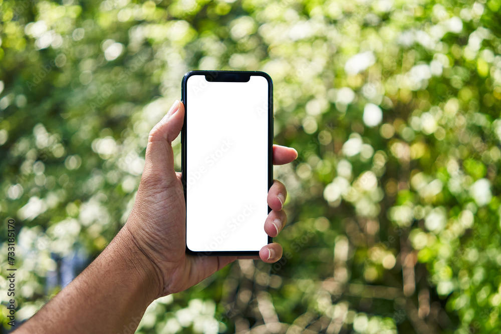 Man holding smartphone showing white blank screen at park Man holding smartphone showing white blank screen at park