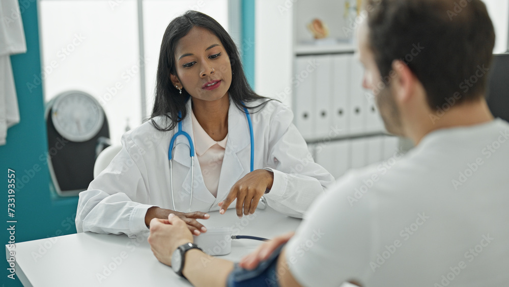 Doctor and patient sitting on table measuring pulse using tensiometer at the clinic