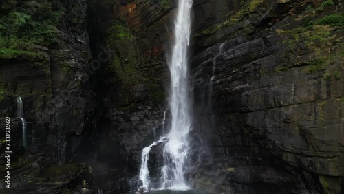 A majestic high tropical waterfall falling its stream on black rocks. Laxapana falls in Sri Lanka photo