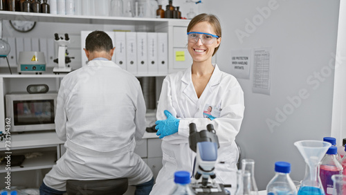 Two amiable scientists  best mates  sitting with arms crossed  engrossed in serious lab work in a bustling medical research laboratory