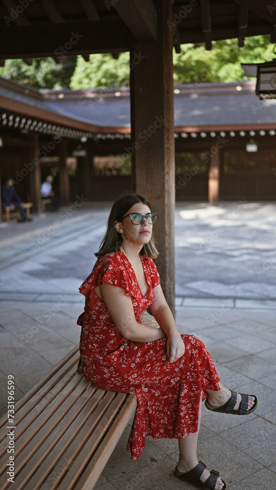 Beautiful, glasses-toting hispanic woman indulging in tranquil solitude while sitting on a bench at tokyo's meiji temple, taking in all the summer's green amidst the bustle of japanese culture. Beautiful, glasses-toting hispanic woman indulging in tranquil solitude while sitting on a bench at tokyo's meiji temple, taking in all the summer's green amidst the bustle of japanese culture.
