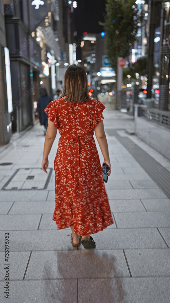 Beautiful young hispanic woman walking away at the street of tokyo