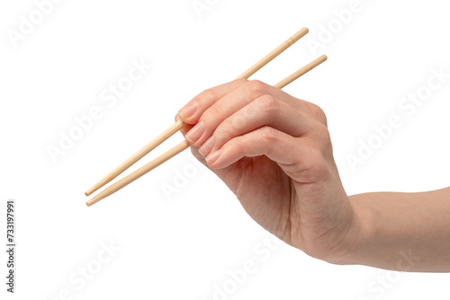 Female hand holding wooden sushi chopsticks isolated on white background.