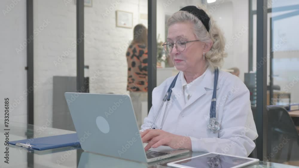 Old Lady Doctor Typing on Laptop Old Lady Doctor Typing on Laptop