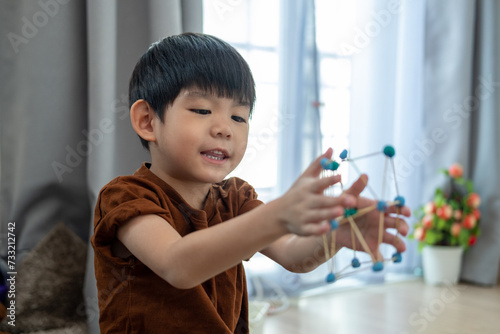 Asian boy playing with plasticine in the room photo