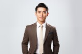 Portrait of a Young Asian businessman in a formal standing pose isolated on a white background.