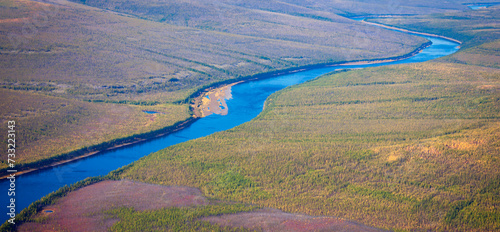 Top view of the autumn Siberian taiga and the Tunguska River with its tributary.
