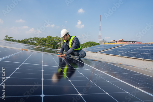 Service Engineer use tablet working inspection installation solar cell on the roof. Technician maintenance solar cells on roof factory. Technology solar energy renewable.