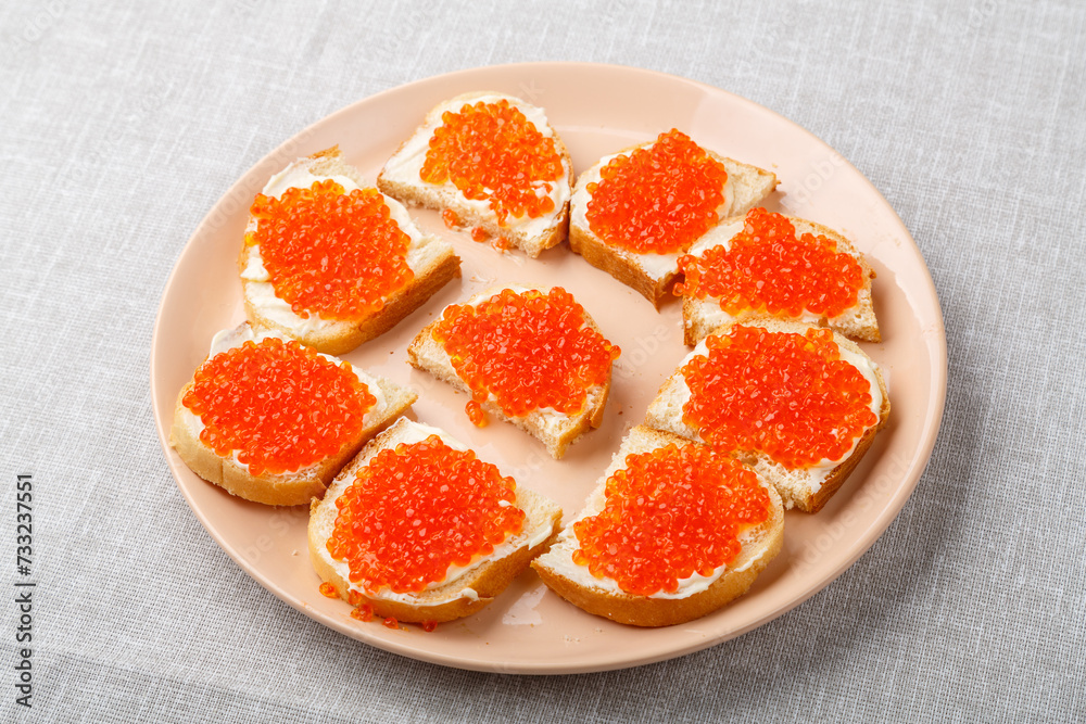 Sandwiches with red caviar on the table on a white tablecloth