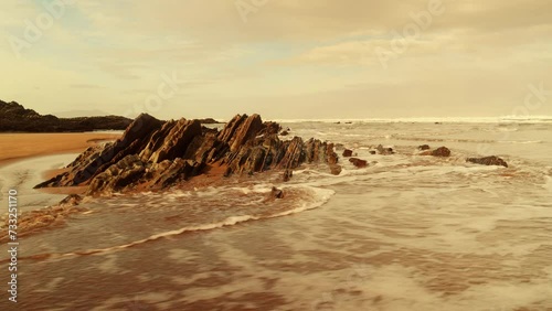 Amanecer en la playa con la marea subiendo y un mar enorme photo