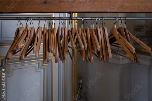 Foto des cintres en bois vides sur un portant à vetement dans un vestiaire